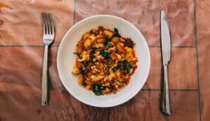 a plat of cramry pasta with thick sauce and fresh herbs.